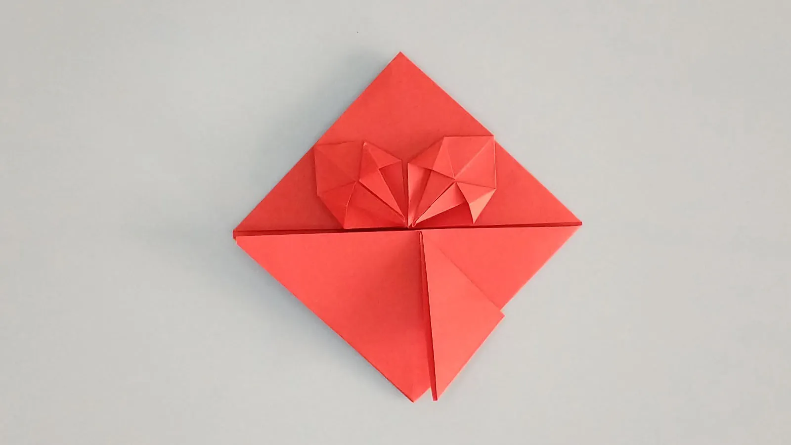 Plegar corazón de origami con papel paso 30