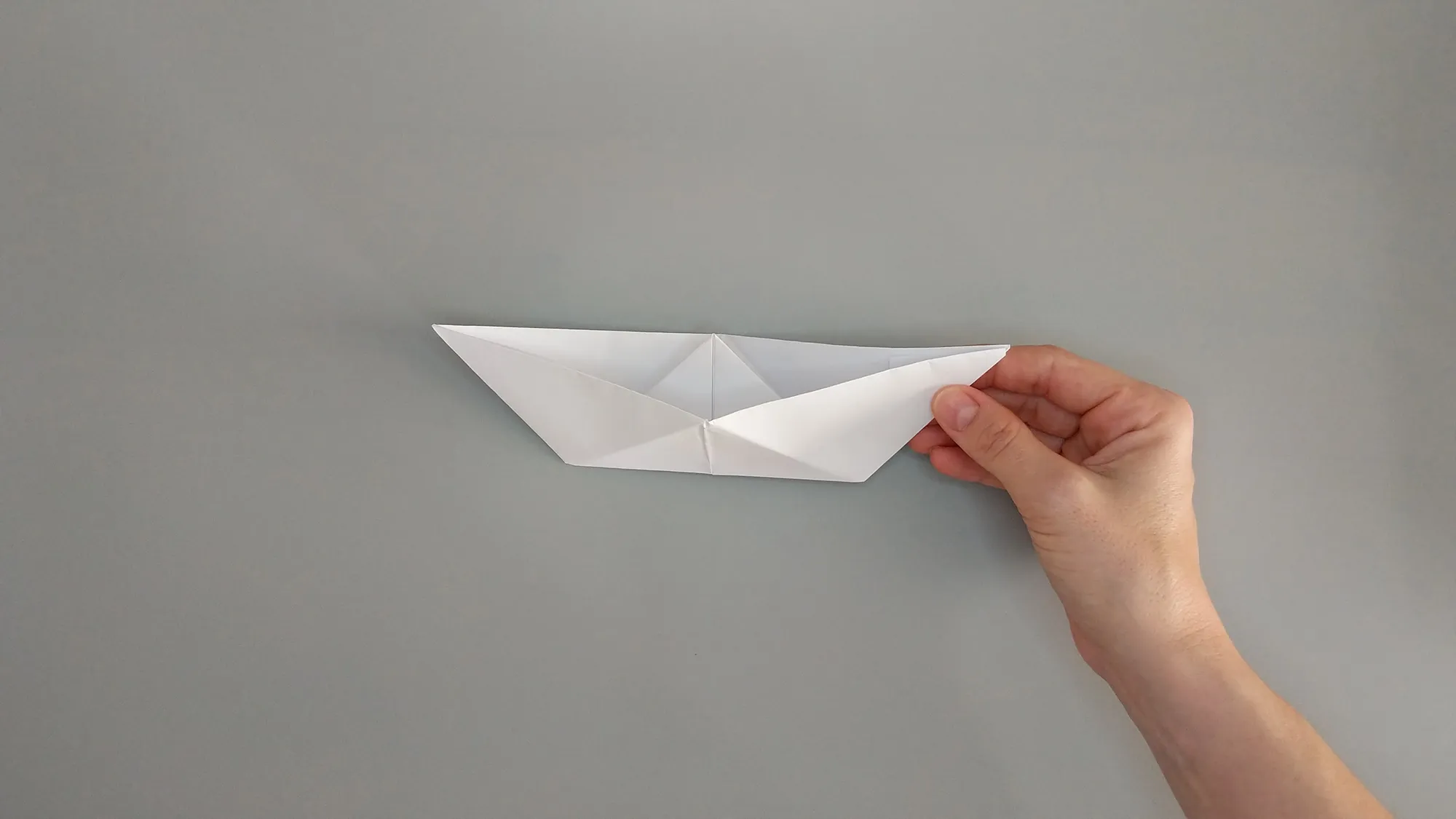 Folding an origami boat from paper. Illustration with instructions number 6